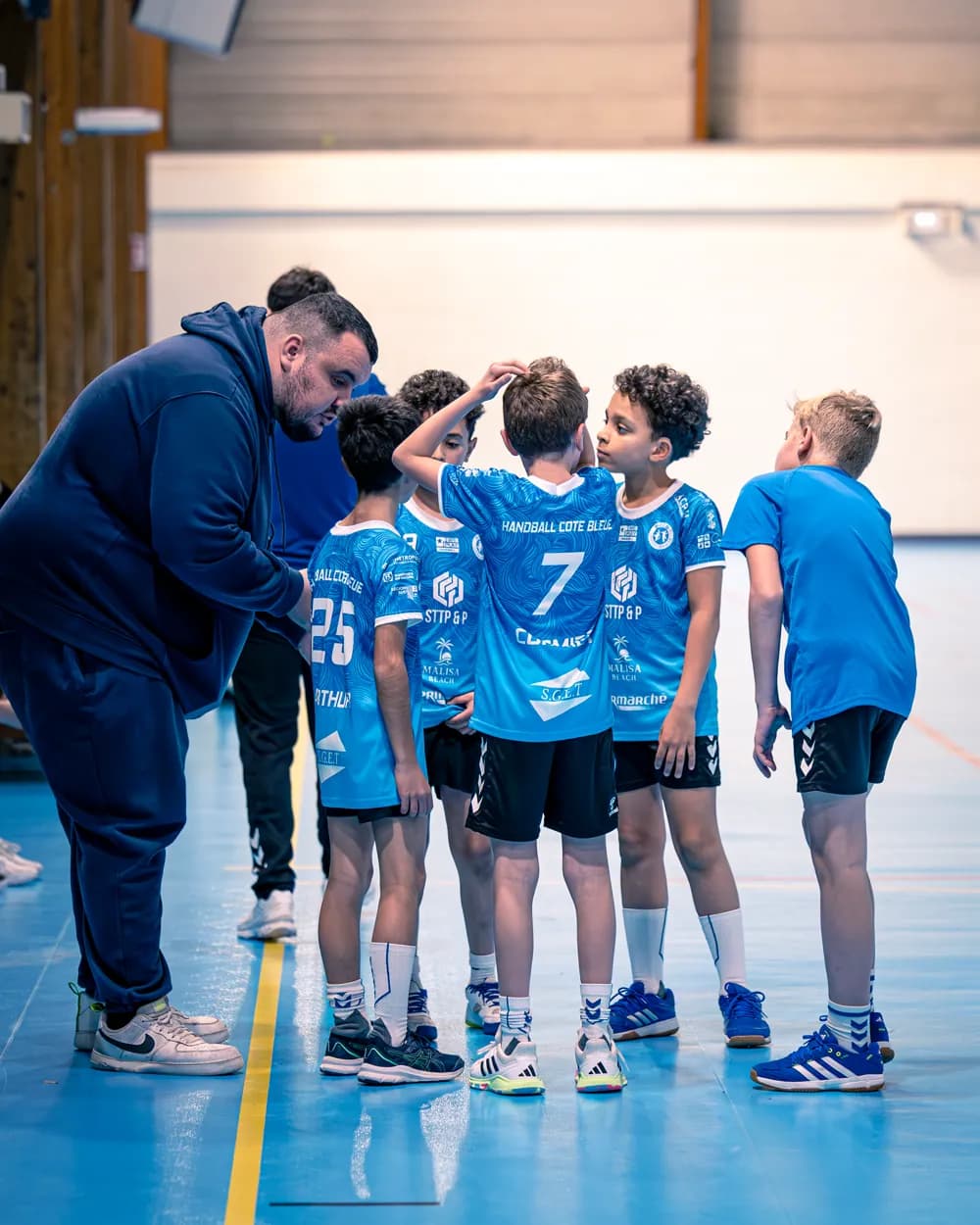 Un éducateur et ses jeunes joueurs